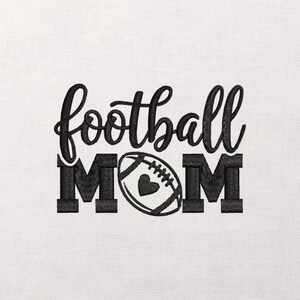 Op de afbeelding: Zwart geborduurd ontwerp op een witte achtergrond. De tekst luidt "football MOM" in een scriptlettertype, met een voetbalafbeelding in plaats van de "O" in MOM. De voetbal heeft een hart in het midden.