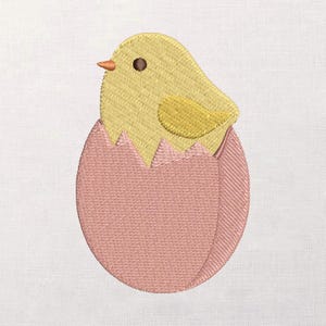 May include: Embroidered image of a yellow chick hatching from a pink egg. The chick has a small orange beak and a dark brown eye. The eggshell is a light pink colour, with a textured appearance. The design is suitable for Easter or spring-themed crafts.