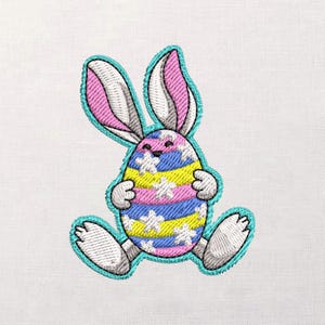 May include: Embroidered Easter bunny design. The bunny is in the shape of an egg, with a blue outline. The egg has horizontal stripes of yellow, blue, and pink, with white star accents. The bunny has pink and white striped ears and white paws.