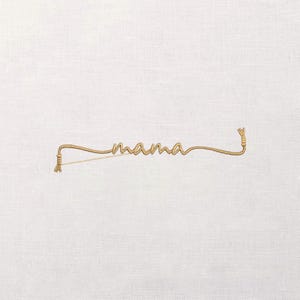 Op de afbeelding: Een goudkleurig geborduurd woord "mama" op een witte achtergrond. Het woord is in een cursief lettertype en het borduurwerk heeft een touwachtige textuur. De uiteinden van het borduurwerk zijn geknoopt.