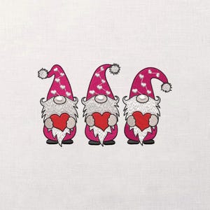 May include: Three embroidered gnomes with pink hats dotted with white hearts and white pom-poms. Each gnome has a white beard and is holding a red heart. The gnomes are on a white background.
