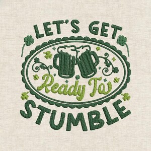 May include: Embroidered design with the text "Let's Get Ready To Stumble" in green and light green. The design includes two beer mugs and shamrocks, perfect for St. Patrick's Day.