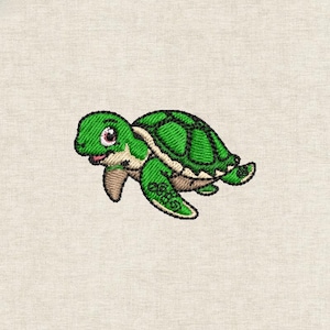 Puede incluir: Tortuga marina verde bordada con un patrón de caparazón detallado, detalles en beige claro y una cara sonriente. La tortuga tiene un contorno negro y está sobre un fondo neutro.
