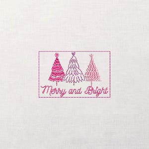 Puede incluir: Diseño bordado con tres árboles de Navidad en tonos rosas, encerrados en un marco rectangular. El texto "Merry and Bright" está debajo de los árboles. El diseño está sobre un fondo de tela blanca.