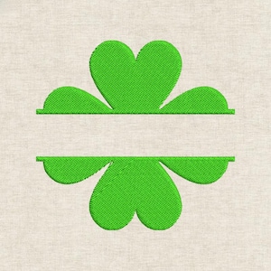 May include: Green embroidered shamrock design with a space for personalization. The shamrock has three heart-shaped leaves above and below a horizontal line. The design is on a beige fabric background.