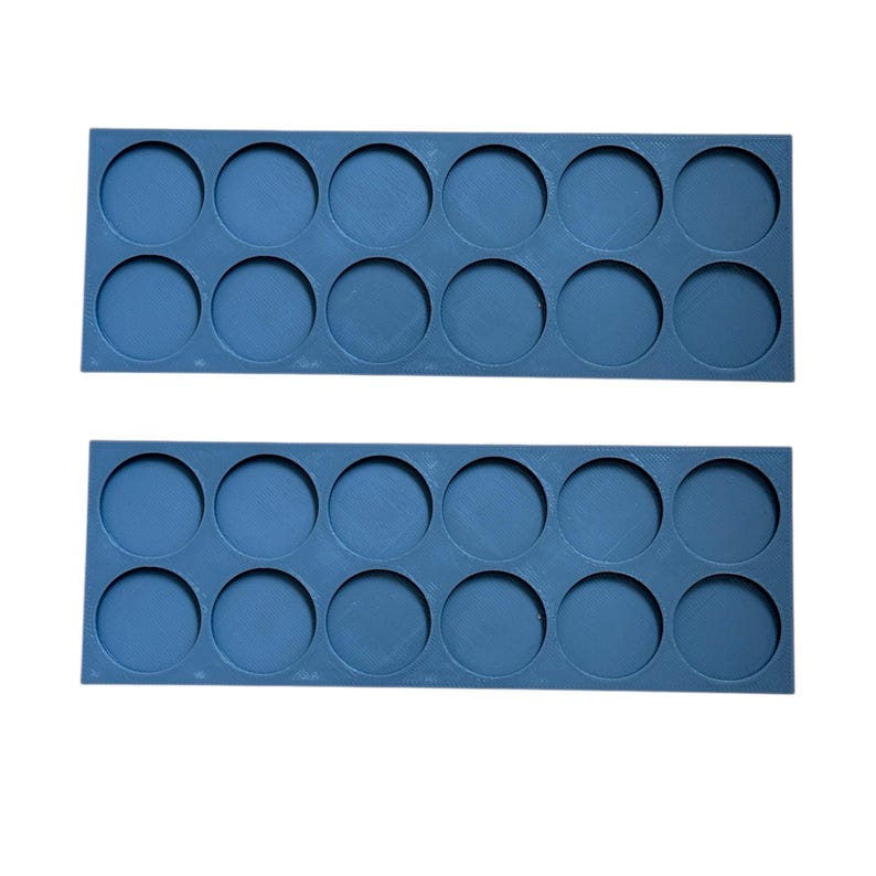 May include: Two rows of blue plastic paint pot holders. Each row has 8 circular indentations for holding paint pots.