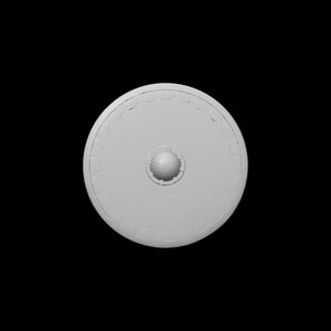 May include: A light gray, circular shield with a central, raised boss and a decorative border. The shield is set against a black background, highlighting its shape and design. The boss appears to be approximately 3 inches in diameter.
