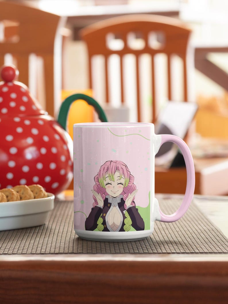May include: A pink and white ceramic mug with a pink handle. The mug features a cartoon image of a pink-haired anime character with green eyes and a pink and green outfit. The character is smiling and has her hands raised in a gesture of excitement.