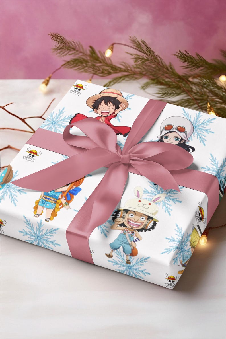Pu&ograve; includere: Regalo confezionato con carta bianca decorata con personaggi dei cartoni animati e fiocchi di neve blu. Un nastro e un fiocco rosa polveroso adornano il regalo. I personaggi sono della serie anime One Piece.