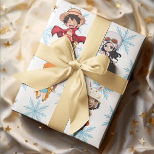 Pu&ograve; includere: Una confezione regalo decorata con personaggi anime e fiocchi di neve, legata con un nastro di raso dorato. La scatola presenta illustrazioni di personaggi dei cartoni animati. Lo sfondo &egrave; un tessuto color crema con accenti di stelle dorate.