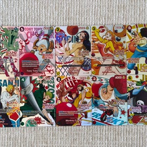 May include: A collection of ten One Piece trading cards featuring colorful illustrations of characters including Brook, Tony Tony Chopper, Nico Robin, Nami, Usopp, Sanji, Roronoa Zoro, Monkey D. Luffy, Franky, and Jinbe, each with game stats and text.