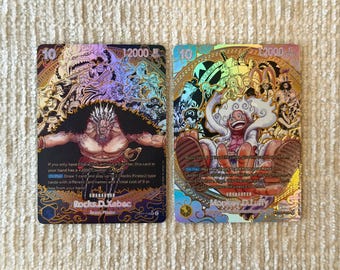 Puede incluir: Dos cartas coleccionables de One Piece con detalles en lámina holográfica. La carta izquierda muestra a Rocks D. Xebec con un coste de 10 y 12000 de poder. La carta derecha muestra a Monkey D. Luffy en forma Gear 5 con texto impreso.
