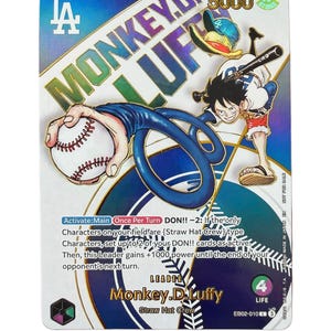 May include: A trading card featuring the character Monkey D. Luffy from the "One Piece" anime. The card has a blue background with the text "MONKEY.D.LUFFY" and an illustration of Luffy with a baseball and bat. The card also includes game instructions.