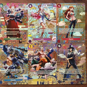 May include: Six collectible trading cards from the One Piece anime series. The cards display colourful illustrations of Yamato, Uta, Nami, Kaido, Enel, and Rob Lucci, with character names and numerical values.