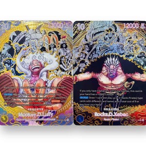 May include: Two One Piece trading cards featuring Monkey D. Luffy and Rocks D. Xebec. The Luffy card has a gold background with a laughing character, while the Xebec card features a dark background with a muscular figure and detailed text.