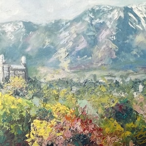 May include: A painting of a white building with a mountain range in the background. The building is surrounded by trees and bushes. The mountain range is covered in snow. The painting is done in a style that is reminiscent of impressionism.