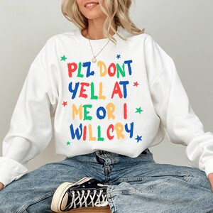 Może przedstawiać: Biała bluza z kolorowym nadrukiem, na kt&oacute;rym widnieje napis "Plz don't yell at me or I will cry".