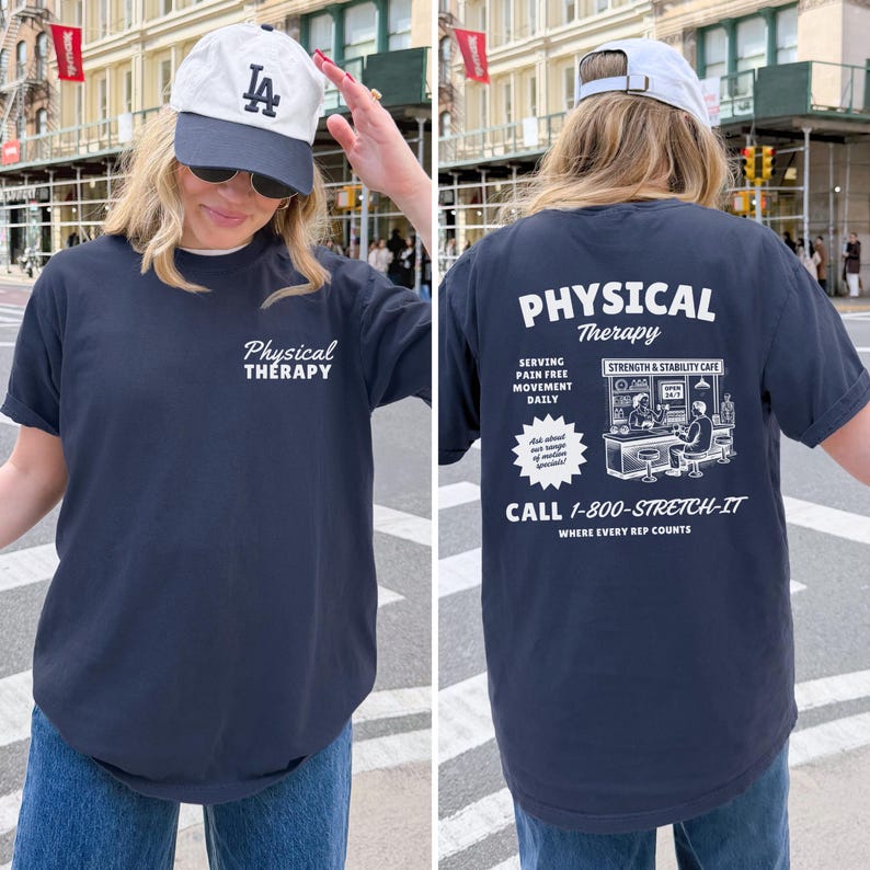 Puede incluir: Camiseta azul marino con el texto "Physical Therapy" en la parte delantera y trasera. La parte trasera de la camiseta presenta un gr&aacute;fico de un caf&eacute; y el texto "Serving Pain Free Movement Daily" y "Call 1-800-STRETCH-IT".