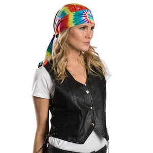 May include: A woman wearing a black leather vest with a tie-dye bandana on her head. The bandana is a rainbow of colors, including red, orange, yellow, green, blue, and purple.