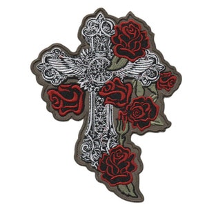 Pode incluir: Um remendo bordado com uma cruz prateada com detalhes ornamentados e cinco rosas vermelhas. A cruz é cercada por folhas e videiras verdes. O remendo está sobre um fundo marrom.