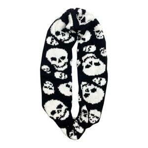 May include: Black and white knit infinity scarf with a skull pattern.