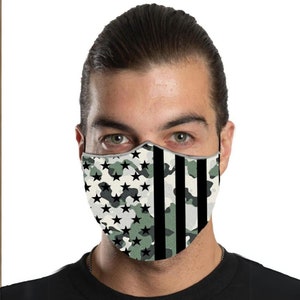 May include: A face mask with a camouflage pattern featuring stars and stripes in black, white, and green.