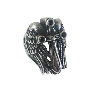 May include: A silver ring with a cross and wings design. The cross has a sword in the center and three black gemstones. The wings are detailed and intricate.