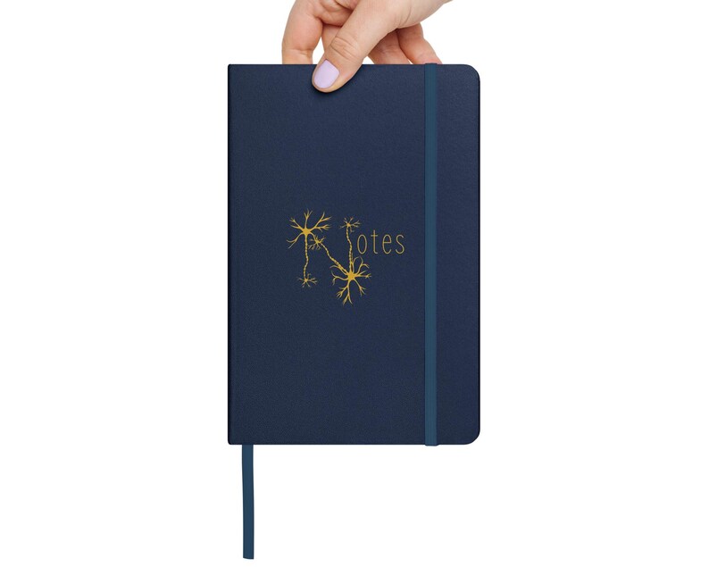 May include: A dark blue notebook with a gold neuron illustration and the word "Notes" printed on the cover. The notebook has a blue ribbon bookmark.