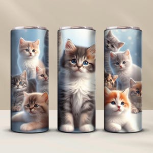 Könnte beinhalten: Drei Edelstahlbecher mit blauem Hintergrund und Bildern von süßen Kätzchen. Die Becher zeigen verschiedene Kätzchen in verschiedenen Posen, darunter ein grau-weißes Kätzchen mit blauen Augen, ein braun-weißes Kätzchen und ein graues Kätzchen.