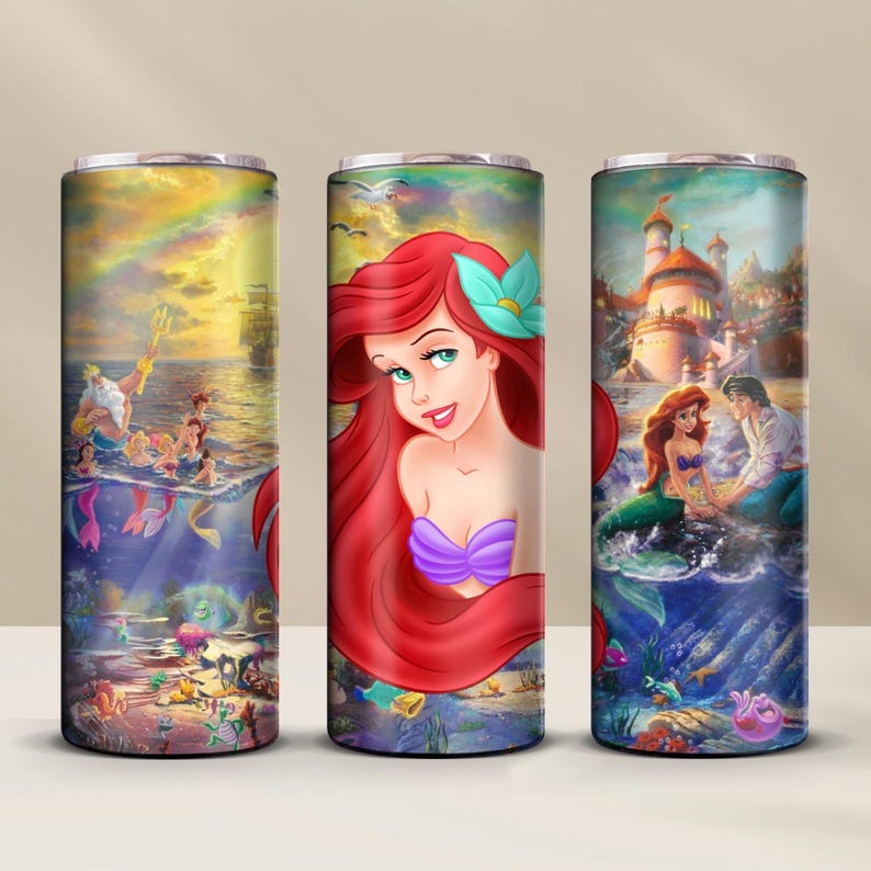 May include: Three stainless steel tumblers with different images of Ariel from The Little Mermaid. The first tumbler features Ariel with a seashell bra and a purple tail, the second tumbler features Ariel with a seashell bra and a purple tail, and the third tumbler features Ariel with a seashell bra and a purple tail.