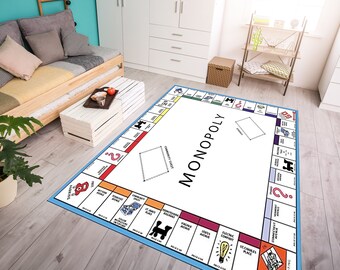 Könnte beinhalten: Ein blauer und weißer Monopoly-Spielbrettteppich mit dem Wort "MONOPOLY" in Schwarz in der Mitte. Der Teppich zeigt das klassische Monopoly-Spielbrettdesign mit den Namen der Grundstücke und den Feldern.