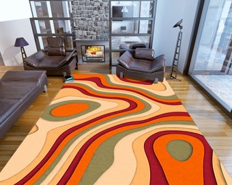 May include: Abstract area rug with a wavy, layered design in shades of orange, red, and green. The rug has a cream-colored background.