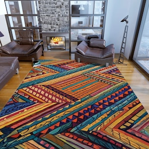 May include: A colourful geometric rug with a multi-coloured pattern of stripes, triangles, and squares. The rug is laid out on a hardwood floor in a living room setting.