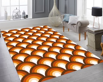 Puede incluir: Una alfombra de salón de color marrón, naranja y blanco con un patrón geométrico de arcos superpuestos. La alfombra está sobre un suelo de baldosas en un salón.