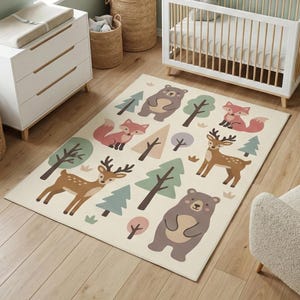 May include: A rectangular area rug with a cream background featuring cartoon illustrations of woodland animals and trees in shades of brown, green, and pink. The rug is placed on a light wood floor, suitable for a nursery or playroom.