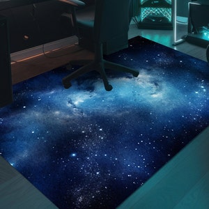 May include: A dark blue galaxy rug with a white nebula and white stars. The rug is on a wooden floor.