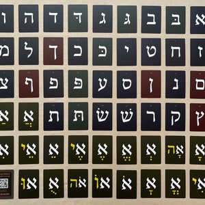 May include: A set of 45 cards featuring the Hebrew alphabet, with each card displaying a different letter in black and white on a coloured background. The cards are arranged in rows and columns, with the letters in alphabetical order. The cards are labelled with the Hebrew letter and its English transliteration.