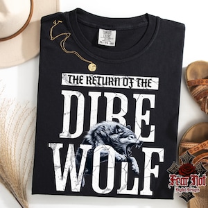 May include: Black t-shirt with a white graphic of a wolf with the text "The Return of the Dire Wolf".