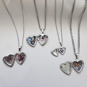 May include: Three silver necklaces with heart-shaped locket pendants. Each locket has a different photo inside. One locket has the initials "A+K" engraved on the outside.