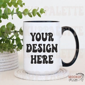May include: White ceramic mug with a black rim and handle. The mug has the text "YOUR DESIGN HERE" in a retro font.