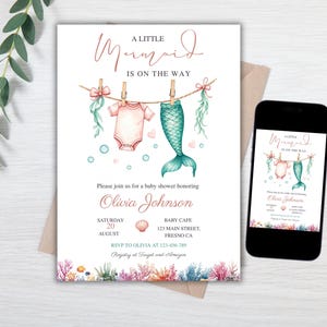 May include: A baby shower invitation card and a smartphone displaying the same design. The card features the text A LITTLE MERMAID IS ON THE WAY, a watercolor illustration of a baby onesie and mermaid tail on a clothesline, and coral reef art.