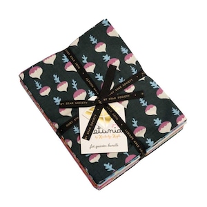 May include: A fat quarter bundle of fabric featuring a dark teal background with a repeating pattern of white, pink, and blue radish-like shapes. The bundle is tied with a black ribbon and a tag that reads "etunia by Kimberly Knight".