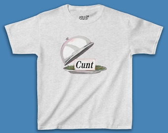 Może przedstawiać: Szary T-shirt z srebrną kopułą do serwowania nad talerzem z zieloną sałatą i białą kartką z napisem "Cunt".