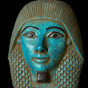 May include: A turquoise blue Egyptian pharaoh mask with intricate details. The mask features a serene expression with inlaid eyes and a patterned headdress.