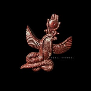Peut inclure: Sculpture brun-rouge d'une déesse cobra égyptienne avec des ailes déployées, un disque solaire et un corps de serpent. Le texte "COBRA GODDESS" est visible. La sculpture est sur fond noir.