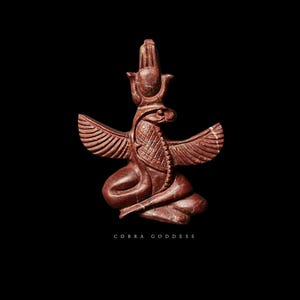 Op de afbeelding: Roodbruin beeld van een cobra-godin met uitgespreide vleugels, zittend op een voetstuk. Het beeld heeft ingewikkelde details en staat tegen een zwarte achtergrond. De tekst "COBRA GODDESS" staat onderaan.