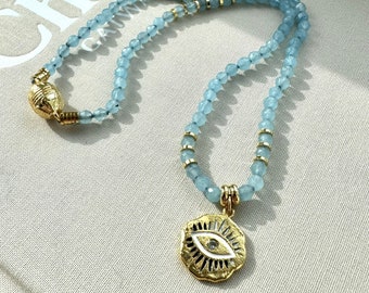Light blue short necklace embellished with gold plated eye pendant