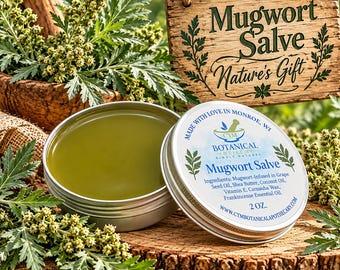May include: A round metal tin of green Mugwort Salve with a white label listing ingredients including grape seed oil, shea butter, coconut oil, vitamin E, carnauba wax, and frankincense essential oil, marked as 2 oz.