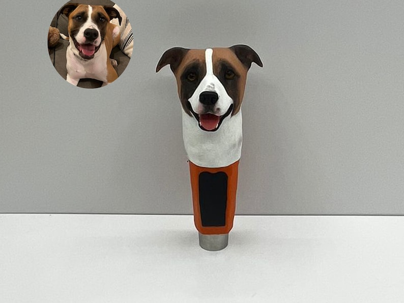 May include: A brown and white dog head beer tap handle. The handle is orange with a black label.