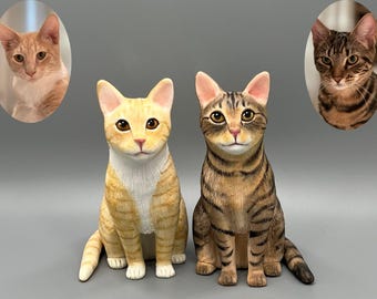 May include: Two realistic cat figurines, one orange and white with tabby markings, the other brown and black with tabby markings. Both are sitting with their paws tucked underneath them.